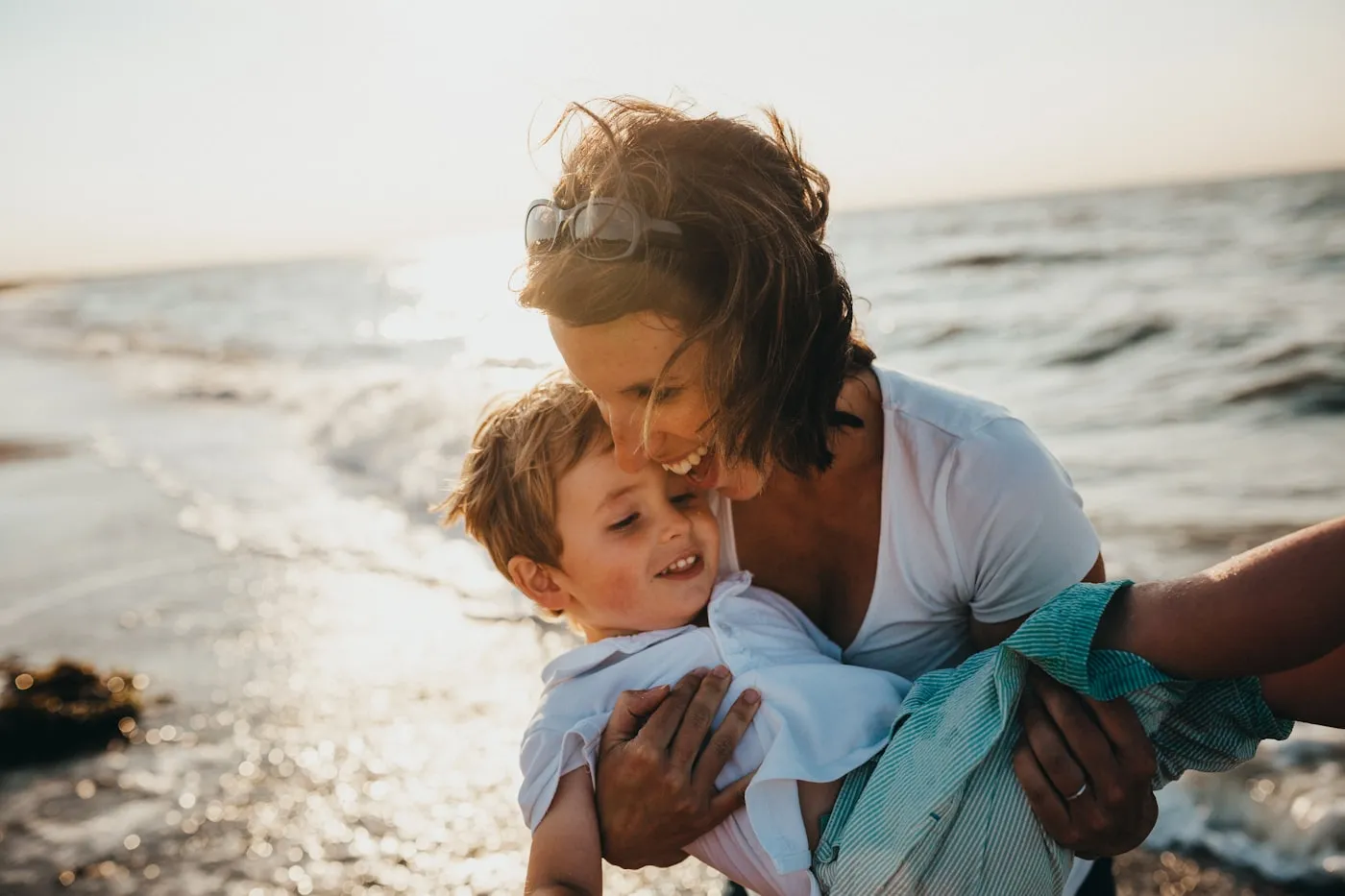 Madre e figlio che si abbracciano serenamente al tramonto